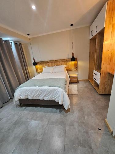 una camera da letto con un letto grande in una stanza di Rustic Charm a Lilongwe