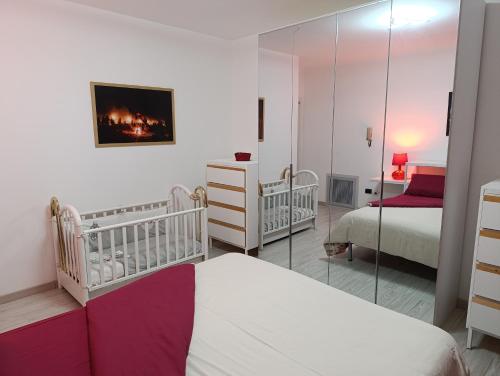 Un dormitorio con dos camas y un espejo. en Pignola Maison, en Pignola