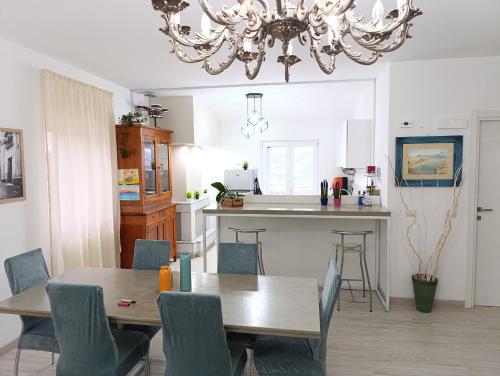 comedor y cocina con lámpara de araña en Pignola Maison, en Pignola