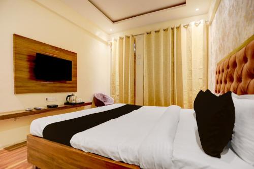 a bedroom with a large bed and a television at Hotel O Gangay in Prayagraj