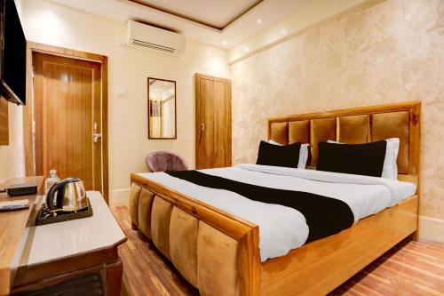 a bedroom with a large bed and a desk at Hotel O Gangay in Prayagraj