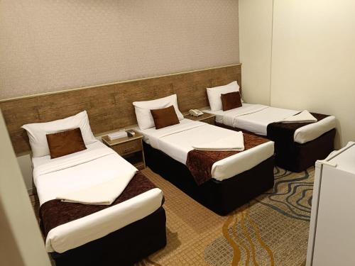 a room with three beds in a room at فندق مناير الاصول in Al Khansāk