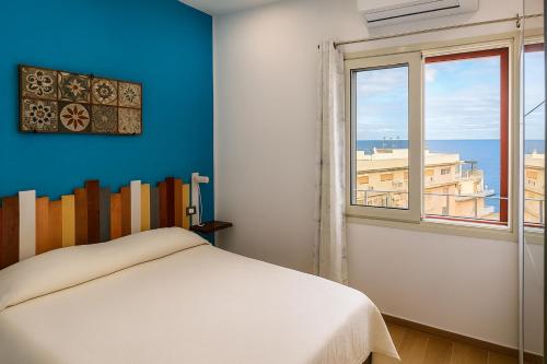 a bedroom with a bed and a window at RineddaHouse Arenella - Vista Mare Panoramica a Palermo con Parcheggio privato in Palermo