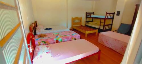 een kleine kamer met 2 bedden en een stoel bij cachoeira do nono in Socorro