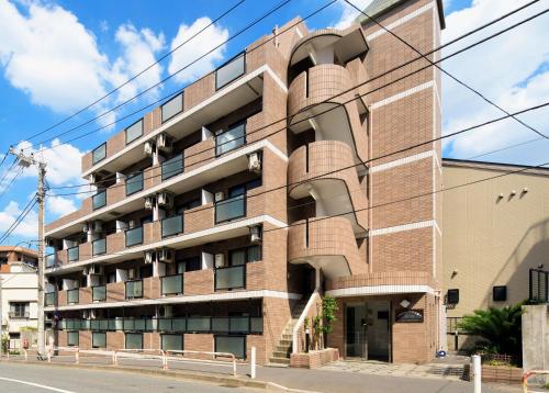 an apartment building on a city street at MIYAVI#407 3min walk Narimasu Station, 3 people, double bed & sofa, Tokyo's largest Don Quijote in Tokyo