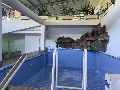 a swimming pool in a building with blue tiles at Full Encarnacion House in Encarnación