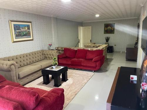 a living room with a red couch and a table at Full Encarnacion House in Encarnación