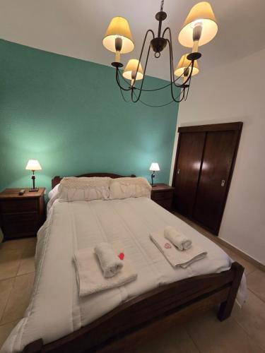 a bedroom with a large bed with towels and a chandelier at Italia Bella in Pergamino