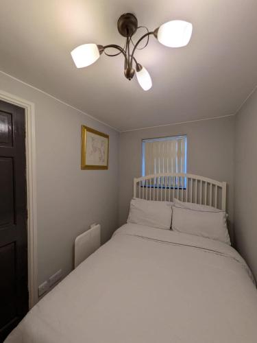 a bedroom with a white bed with a ceiling fan at Bright Comfortable 1 Bedroom Flat in Neepsend