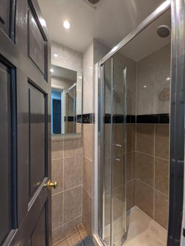 a shower with a glass door in a bathroom at Bright Comfortable 1 Bedroom Flat in Neepsend
