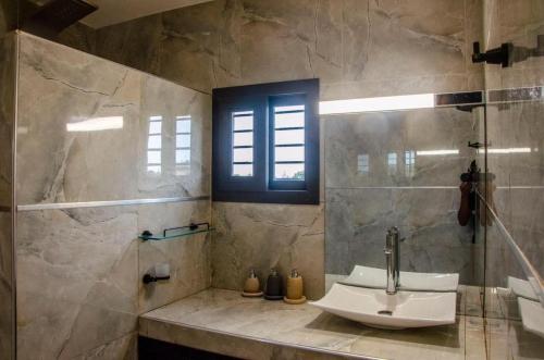 baño con lavabo y ducha con ventana en Villa Complexe Luxueux Saly-Malikunda, en Saly Portudal