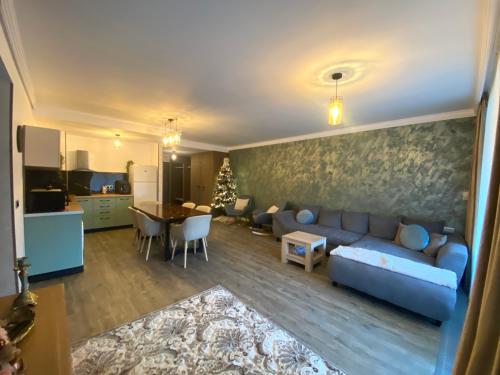 un salon avec un canapé bleu et une cuisine dans l'établissement Fabulous Views Silver Mountain 3 Rooms Apartment, à Poiana Brasov