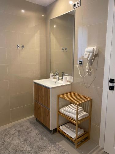 une salle de bain avec un lavabo et un miroir dans l'établissement Fabulous Views Silver Mountain 3 Rooms Apartment, à Poiana Brasov