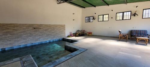 a swimming pool in a room with a brick wall at Pousada Itatiba Holliday in Itatiba