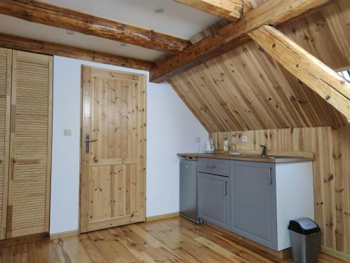 une cuisine avec des plafonds en bois et une porte dans l'établissement Dom Nad Potokiem, à Proszowa