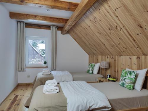 une chambre avec deux lits et une fenêtre dans l'établissement Dom Nad Potokiem, à Proszowa