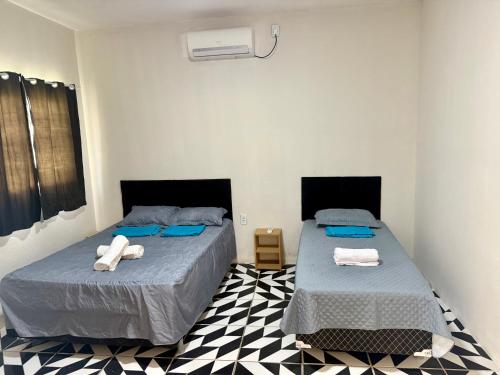 two beds in a room with towels on them at Casa no centro na Praia do Preá/CE in Prea