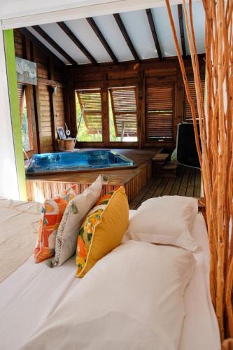 a bedroom with a bed and a tub in a room at Villa Bel Arbre in Saint-François