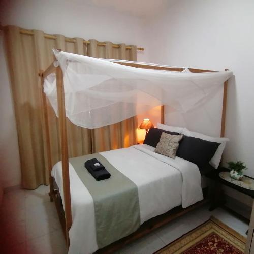 a bedroom with a bed with a canopy at Villa Moni in Zomba