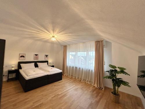 a bedroom with a bed and a large window at Basilisk Homes - in Grenzach-Wyhlen bei Basel - 4 x Moderne Fewos je 1bis2, 1bis4 oder 1bis6 Pers mit Küche und Balkon oder Terrasse - Parkplätze vorhanden in Grenzach-Wyhlen