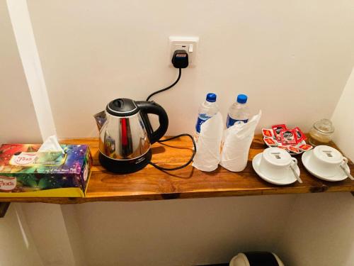 a wooden shelf with a tea kettle and bottles of water at Wild Safari River Cottage Udawalawa in Udawalawe