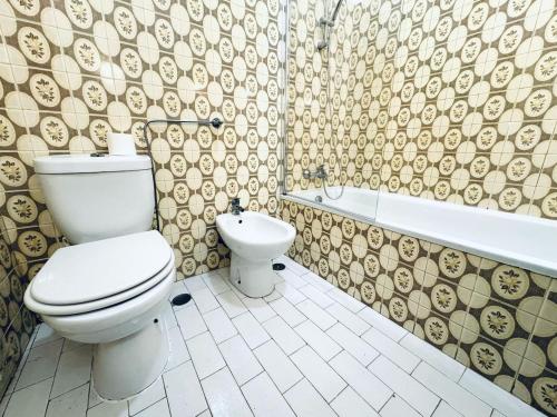 a bathroom with a toilet and a bidet at Faro Family Apartment in Faro