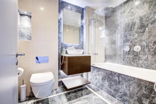 a bathroom with a toilet and a sink and a shower at Mayfair Skyline Residence in London