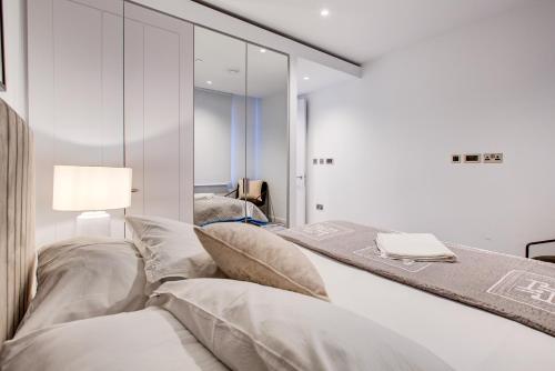 a bedroom with a bed and a mirror at Mayfair Skyline Residence in London