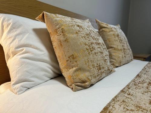 a group of pillows sitting on top of a bed at London Heathrow Apartment - West Drayton in Yiewsley