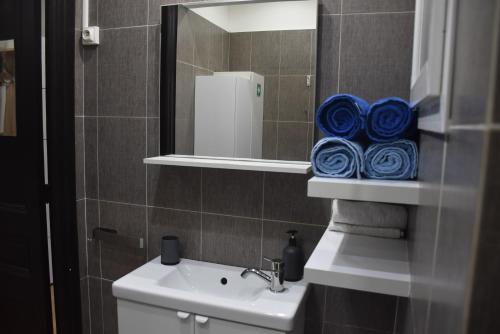 a bathroom with a sink and a mirror with towels at La Maison des Trois in Beausoleil