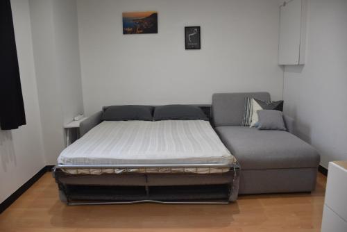 a bed and a couch in a room at La Maison des Trois in Beausoleil