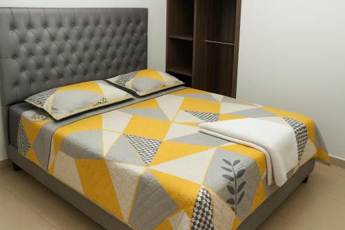 1 cama con edredón y almohadas en Apartaestudios Galanni, en Valledupar