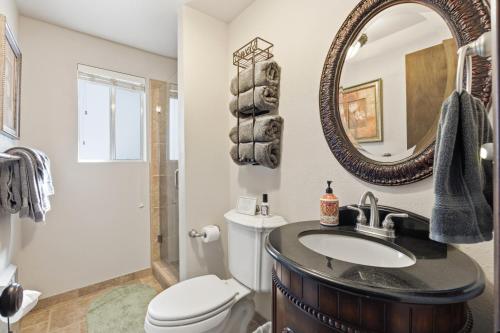 a bathroom with a sink and a toilet and a mirror at Boss's Cabin - Boss-level views, zero stress! in Shaver Lake