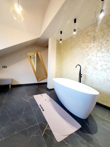 a bathroom with a white tub and a sink at Pensiunea Anton Pann in Sibiu