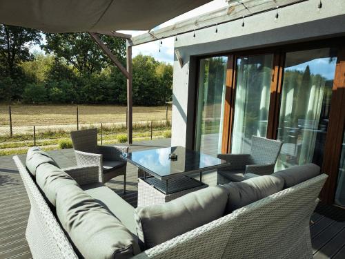 a patio with a couch and a glass table at Apartament Graniczna in Bieniewice