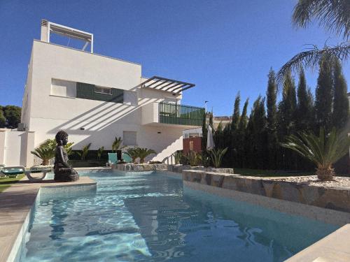une maison avec une piscine devant une maison dans l'établissement Thai Beach Residencial E - Sea View, à Santiago de la Ribera