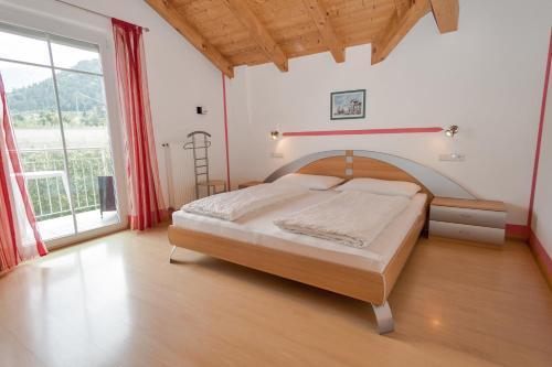 a bedroom with a bed and a large window at Ferienwohnungen Gamper in Tesimo