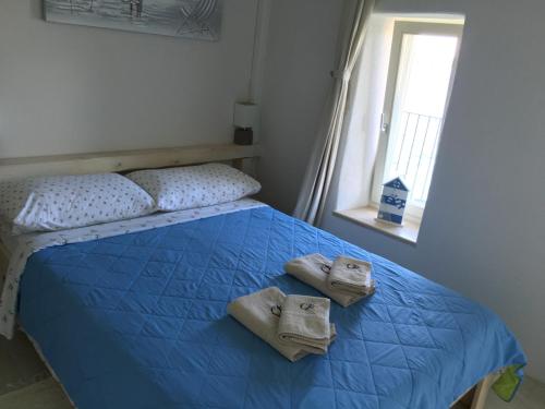 una camera da letto con un letto con asciugamani e una finestra di Casa Svalba a Rovigno (Rovinj)