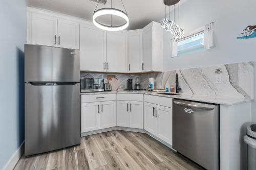 a kitchen with white cabinets and a stainless steel refrigerator at Salty waves 2 in Flagler Beach