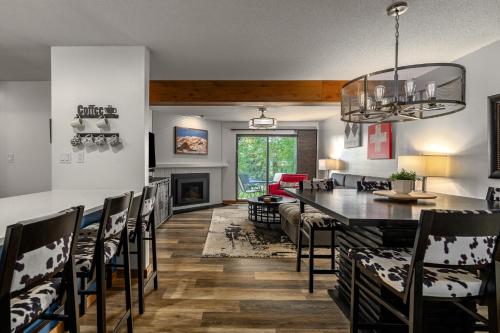 a dining room and living room with a table and chairs at Hot tubs and pool -Looping shuttle- Cozy fireplace in Steamboat Springs