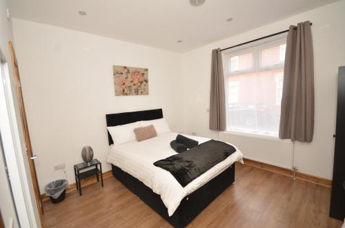 a bedroom with a bed and a large window at JMG HOUSE - Quality Rooms in West Bromwich