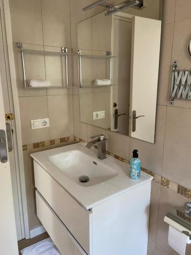 a bathroom with a white sink and a mirror at Palomera, Calafat, piscina, frente al mar, a 5 mn de la playa, wifi, zona residencial in Calafat