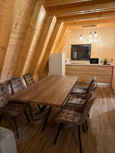 een eetkamer met een houten tafel en stoelen bij Dominic A Frame in Fundata