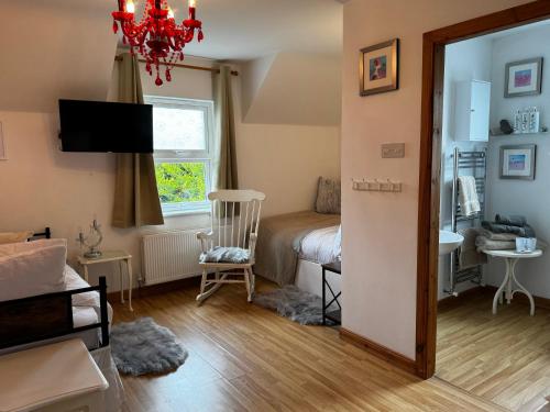Un dormitorio con una cama y una habitación con ventana. en Sidhe Stays Ballycastle, en Ballycastle