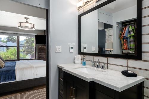 a bathroom with a sink and a bed at Hot tubs and pool -Looping shuttle- Cozy fireplace in Steamboat Springs