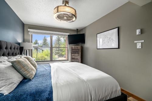 a bedroom with a bed and a large window at Hot tubs and pool -Looping shuttle- Cozy fireplace in Steamboat Springs