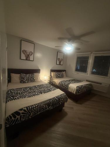 una camera da letto con due letti e un ventilatore a soffitto di Hollywood Apartment FREE Parking & Pool Close to Studios Universal a Los Angeles