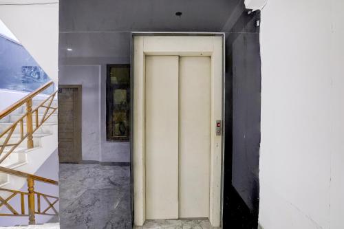 MohaliTownhouse Mohali Bus Terminal Formerly Hotel Hm Crystal的一间有楼梯的房间的白色门