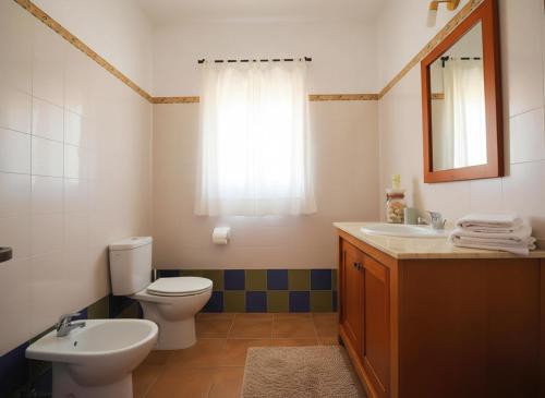ein Badezimmer mit Toilette, Waschbecken und Spiegel in der Unterkunft Casas en el palmar in El Palmar