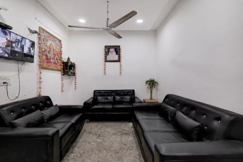 MohaliTownhouse Mohali Bus Terminal Formerly Hotel Hm Crystal的配有黑色皮沙发和天花板的客厅
